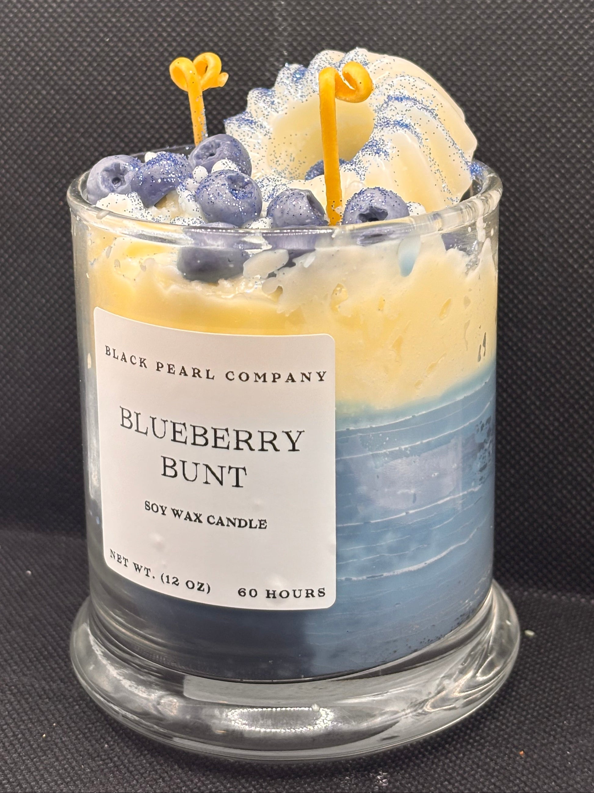 Blueberry bunt candle with a label on a textured surface